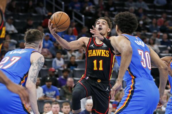 Atlanta Hawks guard Trae Young (11) prepares to shoot as Oklahoma City Thunder guard Vit Krejci, left, and center Olivier Sarr (30) defend during the first half of an NBA basketball game Wednesday, March 30, 2022, in Oklahoma City. (AP Photo/Nate Billings)
