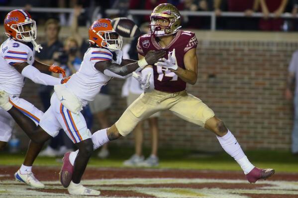 Florida State wide receiver Johnny Wilson (14) is unable to hold onto a pass in the end zone as Florida safety Kamari Wilson (5) defends in the first quarter of an NCAA college football game, Friday, Nov. 25, 2022, in Tallahassee, Fla. (AP Photo/Phil Sears)