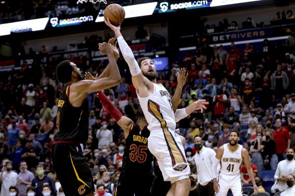 New Orleans Pelicans center Jonas Valanciunas (17) is fouled by Cleveland Cavaliers forward Isaac Okoro (35) while shooting over center Evan Mobley (4) during the fourth quarter of an NBA basketball game in New Orleans, Tuesday, Dec. 28, 2021. (AP Photo/Derick Hingle)