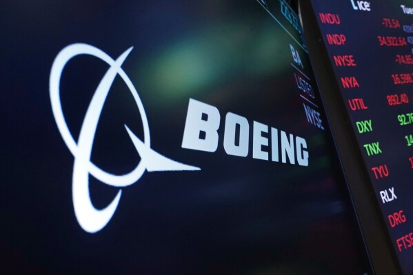 FILE - The logo for Boeing appears on a screen above a trading post on the floor of the New York Stock Exchange, July 13, 2021. Boeing says the head of its 737 jetliner program is leaving the company immediately, paving the way for the aircraft maker to appoint new leadership at the troubled division. (APPhoto/Richard Drew, File)
