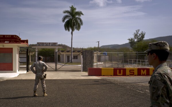 In this photo examined by American military officials, an army soldier, on the right, and a marine stand in front of the doors that separate the Cuban side from the American naval base of Guantanamo Bay, June 6, 2018. (AP photo / Ramon Espinosa, file)