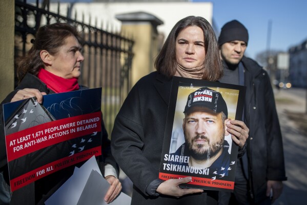 Belarusian opposition leader Sviatlana Tsikhanouskaya, centre, holds a portrait of her jailed husband Syarhey Tsikhanousky attending a protest demanding freedom for political prisoners in Belarus, in front of the Belarus Embassy, in Vilnius, Lithuania, Friday, March 8, 2024. The European Council on Foreign Relations indicates that there are currently over 1,400 political prisoners in Belarusian prisons. (AP Photo/Mindaugas Kulbis)