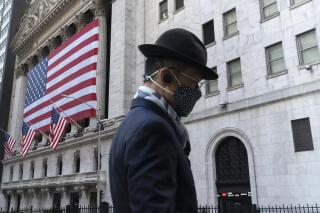 FILE - In this Nov. 16, 2020 file photo a man wearing a mask passes the New York Stock Exchange in New York. After getting mauled most of the year, prices for all kinds of investments seemed to have steadied in the summer and were even heading back up. The recovery was so strong that some investors wondered if Wall Street's “bear market” was coming to an end.  Now, such questions are getting more muted. On Monday, Aug. 22, 2022, the main measure of the U.S. stock market tumbled to its worst loss in two months.  (AP Photo/Mark Lennihan, File)