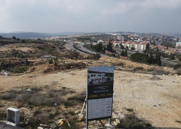 A new housing project sign stands in the Jewish West Bank settlement of Ari'el, Tuesday, Jan. 28, 2020. The population of Jewish settlements in the West Bank surged by more than 3% in 2019, well above the growth rate of Israel's overall population, a settler group said Tuesday. It predicted even higher growth this year thanks to a nascent building boom made possible by friendly policies of the Trump administration. (AP Photo/Ariel Schalit)