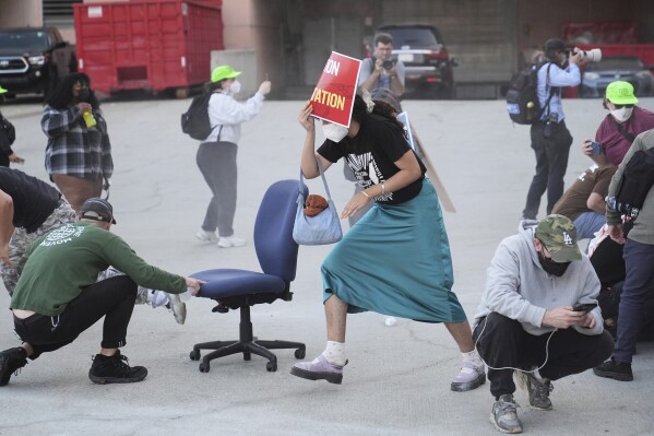 Crowd members react after law enforcement officers fired pepper balls during a protest after federal immigration authorities conducted an operation on Friday, June 6, 2025, in Los Angeles. (AP Photo/Jae C. Hong)