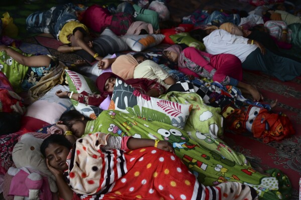 Rohingya women sleep in their tent at a temporary shelter in Meulaboh, Indonesia, on Wednesday, April 3, 2024. They were among 75 people rescued in March from atop the overturned hull of a boat, which capsized off the Indonesian coast. Dozens of other Rohingya refugees died. (AP Photo/Reza Saifullah)