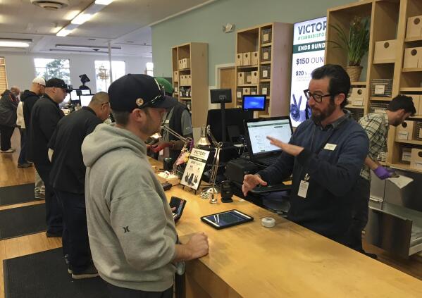 Budtender Austin Pitts, right, assists a customer inside the Harborside cannabis dispensary Thursday, Jan. 4, 2018, in Oakland, Calif. Attorney General Jeff Sessions has rescinded an Obama-era policy that paved the way for legalized marijuana to flourish in states across the country, creating new confusion about enforcement and use just three days after a new legalization law went into effect in California. (AP Photo/Terry Chea)