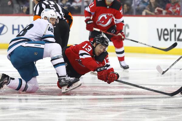 New Jersey Devils center Nico Hischier (13) plays the puck against San Jose Sharks center Tomas Hertl(48) during the first period of an NHL hockey game, Saturday, Oct. 22, 2022, in Newark, N.J. (AP Photo/Noah K. Murray)