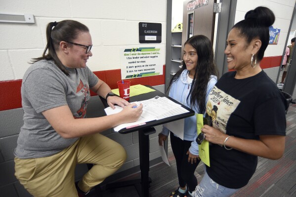 FILE - Social studies teacher Sarah Holloway, left, talks with student Sofia Becerra, center, and Martha Navarro during sixth-grade orientation at Hammond Creek Middle School in Dalton, Ga., Aug. 7, 2023. Under a spending plan approved on Tuesday, March 5, 2024, by a state House committee, Georgia public school teachers would get a $2,500 raise beginning July 1. (Matt Hamilton/Chattanooga Times Free Press via AP, File)