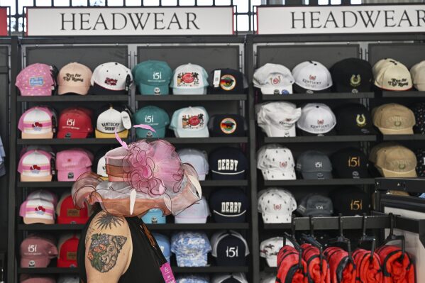 A person walks past hats for sale at Churchill Downs before the 151st running of the Kentucky Oaks horse race Friday, May 2, 2025, in Louisville, Ky. (AP Photo/Jon Cherry)