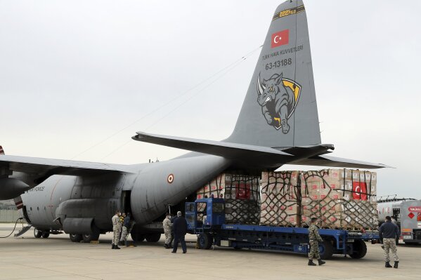 In this handout photo provided by the Turkish Defense Ministry, Turkish soldiers load a Turkish military cargo plane with Personal Protection Equipment donated by Turkey to help United States combat the new coronavirus outbreak, at the Etimesgut airport outside Ankara, Turkey, Thursday, April 30, 2020. Turkey is sending a second planeload of surgical masks, N95 masks and hazmat suits tor U.S. to help the country battle the coronavirus outbreak.(Turkish Defence Ministry via AP)