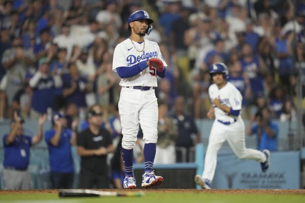 Los Angeles Dodgers' Mookie Betts (50) applauds after scoring off of a single hit by Amed Rosario during the seventh inning of a baseball game against the Cincinnati Reds in Los Angeles, Friday, July 28, 2023. (AP Photo/Ashley Landis)