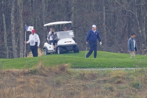 President Donald Trump, center, plays golf at Trump National Golf Club in Sterling, Va., as seen from the other side of the Potomac River in Darnestown, Md., Sunday, Nov. 15, 2020. (AP Photo/Manuel Balce Ceneta)