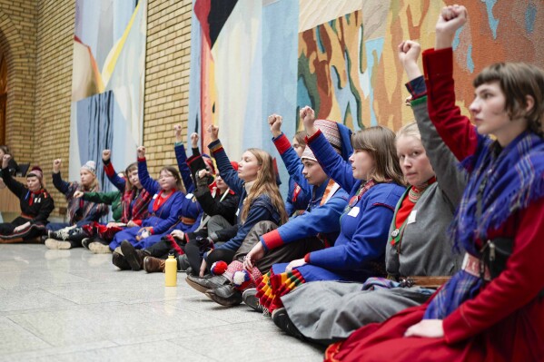 Activists wearing traditional Sami costumes demonstrate inside the central hall of Storting, the Norwegian parliament, in Oslo, Wednesday, Oct. 11, 2023. Dozen of activists, including Indigenous Sami, protested Wednesday saying they are fed up with Norway’s government about a wind farm they want removed in the Fosen district, about 450 kilometers (280 miles) north of Oslo, because they say it endangers the reindeer herders’ way of life. (Håkon Mosvold Larsen/NTB Scanpix via AP)