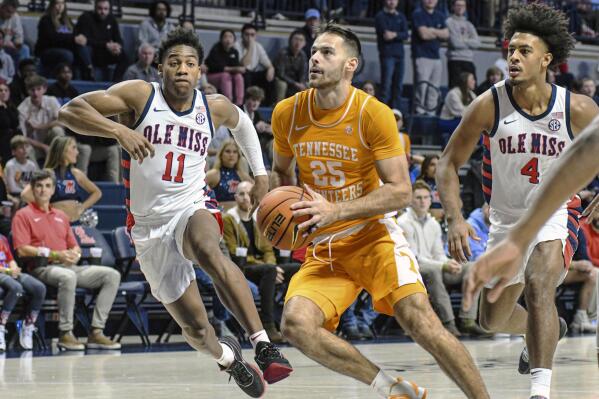 Tennessee guard Santiago Vescovi (25) drives the lane as Mississippi guard Matthew Murrell (11) and Mississippi forward Jaemyn Brakefield (4) defend in the first half in an NCAA college basketball game, Wednesday, Dec. 28, 2022 in Oxford, Miss. (AP Photo/Bruce Newman)