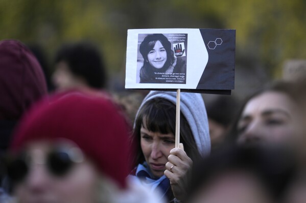 FILE - A woman shows a photo of Giulia Cecchettin, allegedly killed by ex-boyfriend, on the occasion of International Day for the Elimination of Violence against Women, in Milan, Italy, Saturday, Nov.25, 2023. Violence and discrimination against women in Italy is a “prevailing and urgent concern,” a European expert on human rights said Thursday, Dec. 14, in a scathing report that comes amid a national outcry over a gruesome murder of the young woman allegedly by her ex-boyfriend. (AP Photo/Luca Bruno, File)