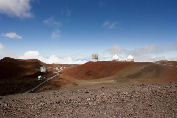 FILE - In this Aug. 31, 2015, file photo, observatories and telescopes sit atop Mauna Kea, Hawaii's tallest mountain and the proposed construction site for a new $1.4 billion telescope, near Hilo, Hawaii. Construction on a giant telescope will start again next week after lengthy court battles and passionate protests from those who say building it on Hawaii's tallest mountain will desecrate land sacred to some Native Hawaiians. State officials announced Wednesday, July 10, 2019, that the road to the top of Mauna Kea mountain on the Big Island will be closed Monday as equipment is delivered to the construction site. (AP Photo/Caleb Jones, File)
