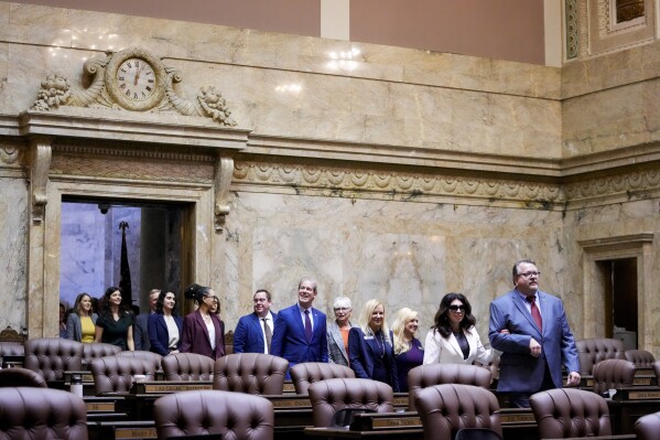 Members of the House, including Rep. Michelle Caldier, R-Gig Harbor, and Rep. Eric Robertson, R-Sumner, at front, walk into the House chambers during opening ceremonies on the first day of the legislative session at the Washington state Capitol, Monday, Jan. 8, 2024, in Olympia, Wash. (AP Photo/Lindsey Wasson)