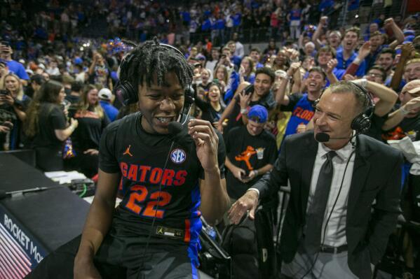 Florida guard Tyree Appleby (22), left, talks with broadcasters as he celebrates Florida's 63-62 win over Auburn during an NCAA college basketball game Saturday, Feb. 19, 2022, in Gainesville, Fla. (AP Photo/Alan Youngblood)