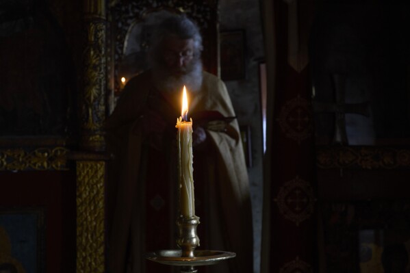 O monge cristão ortodoxo Padre Spyridon conduz a Divina Liturgia na capela do Mosteiro de Panagia Hozoviotissa na ilha de Amorgos, Grécia, no domingo, 30 de março de 2025. (Foto AP/Petros Giannakouris)