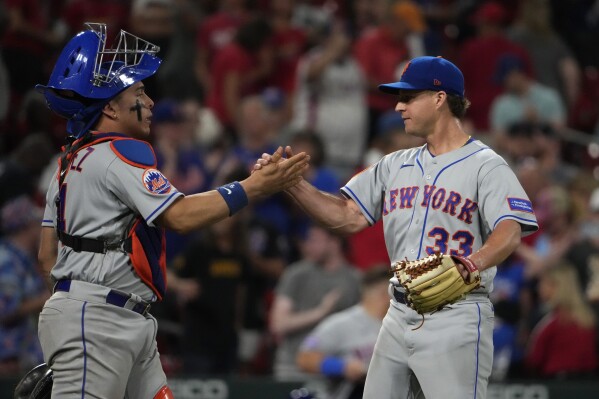 New York Mets relief pitcher Trevor Gott (33) and catcher Francisco Alvarez celebrate a 4-2 victory over the St. Louis Cardinals in a baseball game Thursday, Aug. 17, 2023, in St. Louis. (AP Photo/Jeff Roberson)