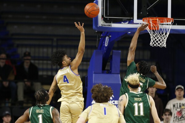 Tulsa guard PJ Haggerty (4) shoots over South Florida guard Brandon Stroud (5) during the first half of an NCAA college basketball game, Saturday, March 9, 2024, in Tulsa, Okla. (AP Photo/Joey Johnson)