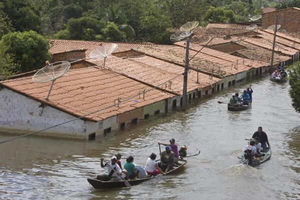 FILE - People travel by boat in a flooded street in Trizidela do Vale, state of Maranhao, Brazil, May 9, 2009. The intensity of extreme drought and rainfall has “sharply” increased over the past 20 years, according to a study published Monday, March 13, 2023, in the journal Nature Water. (AP Photo/ Andre Penner, File)