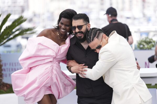 Buliana Simon, from left, director Morad Mostafa and Ziad Zaza pose for photographers at the photo call for the film 'Aisha Can't Fly Away' at the 78th international film festival, Cannes, southern France, Wednesday, May 21, 2025. (Photo by Lewis Joly/Invision/AP)