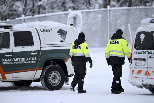 A customs officer walks between Finnish Border Guard vehicles at the Raja Giuseppi international border crossing with Russia in Inari, northern Finland, Tuesday, November 28, 2023. Finland plans to close its last remaining road border with Russia due to migration concerns.  , Prime Minister Petteri Orpo said on Tuesday, accusing Russia of undermining Finland's national security. Finland has already closed seven of eight checkpoints along its long border with Russia this month due to a surge in migrants from the Middle East and Africa. The government accuses Moscow of directing migrants to the Finnish border.  (Emi Korhonen/Retikva, via AP)