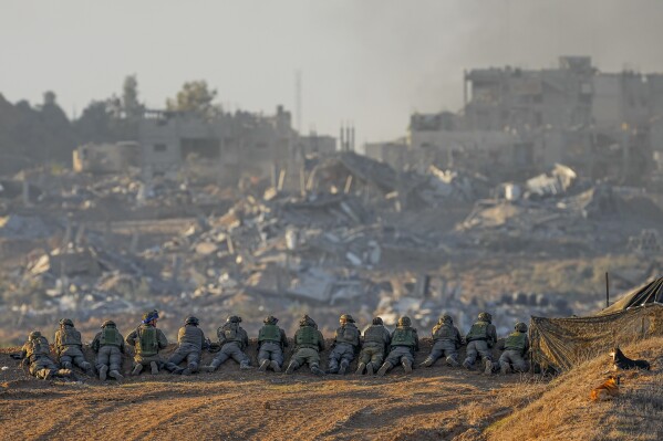 Israeli soldiers take positions near the Gaza Strip border in southern Israel, Monday, Dec. 11, 2023. (AP Photo/Ohad Zwigenberg)