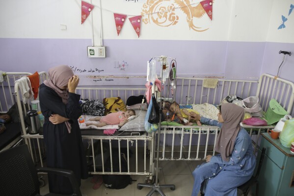 Amira Al-Jojo, left, stands beside her 10-month-old son, Yousef Al-Jojo, who suffers from malnutrition at Al-Aqsa Martyrs Hospital, where he is undergoing treatment, in Deir al-Balah in the central Gaza Strip on Saturday, June 1, 2024. At right is Nuha Al-Khaldi and her child. (AP Photo/ Jehad Alshrafi)