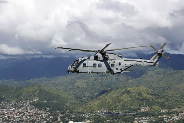 In this undated handout photo provided by the Ministry of Defence on Saturday, Nov. 21, 2020, a Merlin Helicopter from 845 Naval Air Squadron conducting damage surveys in Honduras. The devastation caused by Hurricane Iota is becoming clear as communications are restored after the second Category 4 hurricane in two weeks to blast Nicaragua’s Caribbean coast. The official death toll rose in Nicaragua with victims swept away by swollen rivers or buried in landslides. (LPhot Robert Oates/Ministry of Defence via AP)