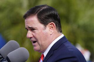 FILE - Arizona Republican Gov. Doug Ducey speaks at a ceremony on Dec. 7, 2021, in Phoenix. Two more bills restricting responses to the coronavirus pandemic are heading to Ducey's desk, including one that would impact the ability of future state leaders to respond to another airborne-spreading disease and a second blocking the state from ever requiring schoolchildren to get a COVID-19 vaccine. (AP Photo/Ross D. Franklin, File)