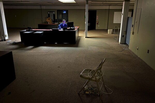 FILE - News Editor Chris Sciria puts the newspaper to bed for the last time from an empty newsroom at The Citizen's 25 Dill St. location in Auburn, N.Y. on Friday, Oct. 22, 2021. After 51 years on Dill St. the newspaper moved its operation to a smaller office space. New York is offering up to $90 million in tax credits for news outlets to hire and retain journalists in an effort to help keep the shrinking local news industry afloat. (Kevin Rivoli/The Citizen via AP, File)
