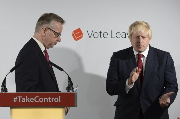 FILE - In this Friday June 24, 2016 file photo Vote Leave campaigners Michael Gove, left, leaves the lectern as Boris Johnson applauds at a press conference at Vote Leave headquarters in London. (Stefan Rousseau/Pool via AP)