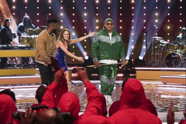 This image provided by CBS shows LL Cool J, right, and hosts Nate Burleson, from left, and Keltie Knight during an episode of the television game show 