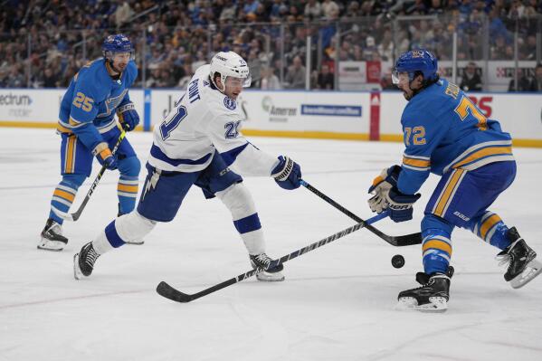 Tampa Bay Lightning's Brayden Point (21) shoots as St. Louis Blues' Justin Faulk (72) and Jordan Kyrou (25) defend during the third period of an NHL hockey game Saturday, Jan. 14, 2023, in St. Louis. (AP Photo/Jeff Roberson)