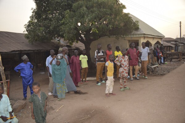 People gather around an area were gunmen kidnapped school children in Chikun, Nigeria, Thursday, March 7, 2024. Gunmen attacked a school in Nigeria's northwest region Thursday morning and abducted at least 287 students, the headteacher told authorities, marking the second mass abduction in the West African nation in less than a week. (AP Photo)