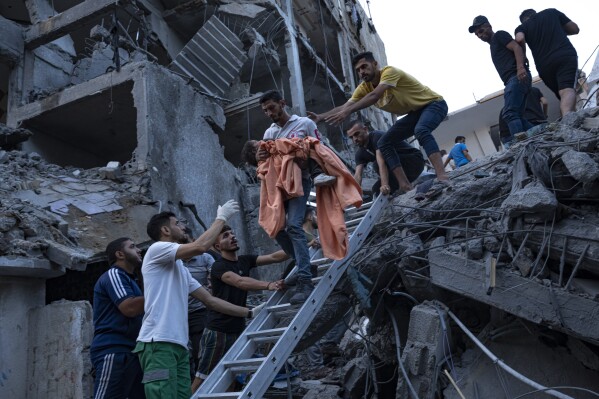 Palestinos rescatan a una niña de los escombros de un edificio residencial destruido luego de un ataque aéreo israelí, el martes 10 de octubre de 2023. (AP Foto/Fatima Shbair)