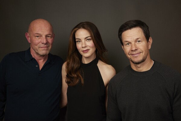Director Simon Cellan Jones, left, poses with actors Michelle Monaghan, center, and Mark Wahlberg in New York on Dec. 9, 2023, to promote their film "The Family Plan." (Photo by Matt Licari/Invision/AP)