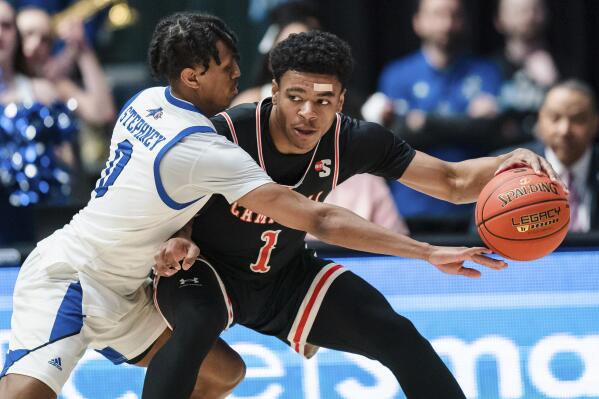 North Carolina Asheville guard Trent Stephney (0) tries to knock the ball away from Campbell guard Ricky Clemons (1) during the first half of the Big South Championship NCAA college basketball game on Sunday, March 5, 2023, in Charlotte, N.C. (AP Photo/Jacob Kupferman)