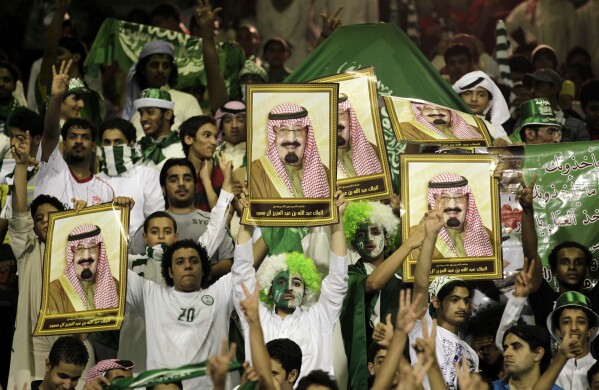 Saudi Arabia fans cheer as they hold pictures of King Abdullah of Saudi Arabia before their 2014 FIFA World Cup Asia qualifying soccer match against Australia at the Prince Muhammad bin Fahd Stadium in the eastern port city of Dammam, Saudi Arabia, Tuesday, Sept. 6, 2011. (AP Photo/Hassan Ammar, File)