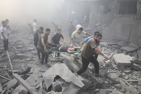 Palestinians evacuate wounded people after an Israeli airstrike in Rafah refugee camp, southern Gaza Strip, Thursday, Oct. 12, 2023. (AP Photo/Hatem Ali)