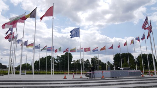 FILE - Two men doing construction work around the flags at NATO headquarters in Brussels, Thursday, July 6, 2023. As the Russian invasion of Ukraine continues with no end in sight, NATO's much-celebrated unity faces fresh strains when leaders gather for their annual summit this week in Vilnius, Lithuania.  Disagreements have been stacking up over admitting Sweden as NATO's 32nd member, boosting military spending and finding a new secretary general.  (AP Photo/Virginia Mayo, Files)