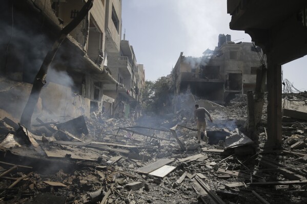 Palestinians look on after an Israeli bombardment of the Nusirat refugee camp in the Gaza Strip, Saturday, June 8, 2024.  (AP Photo/Jehad Alshrafi)