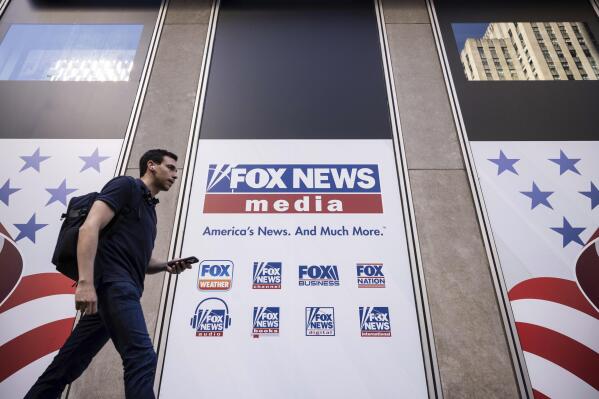 FILE - A person walks past the Fox News Headquarters in New York, Wednesday, April. 12, 2023. Dominion Voting Systems' defamation lawsuit against Fox News for airing bogus allegations of fraud in the 2020 election is set to begin trial on Tuesday, April 18, 2023, in Delaware. (AP Photo/Yuki Iwamura, File)