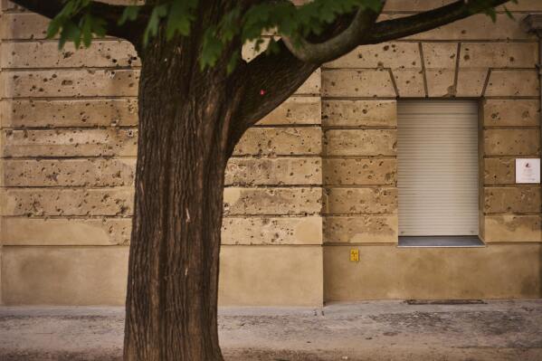 Eighty years after the end of World War II, holes from artillery fire are still visible on the facade of a house in the city center of Berlin, Germany, Friday, May 2, 2025. (AP Photo/Markus Schreiber)
