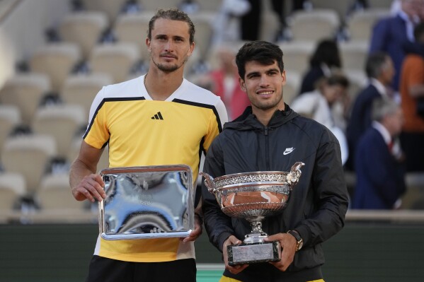 Winner Spain's Carlos Alcaraz, right, and second placed Germany's Alexander Zverev pose with their trophies after the men's final match of the French Open tennis tournament at the Roland Garros stadium in Paris, Sunday, June 9, 2024. (AP Photo/Thibault Camus)