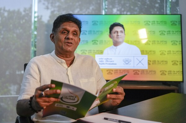 Opposition leader and the presidential candidate of United People's Power Sajith Premadasa speaks holding a copy of his election manifesto during an interview with The Associated Press in Colombo, Sri Lanka, Thursday, Sept. 12, 2024. (AP Photo/Eranga Jayawardena)