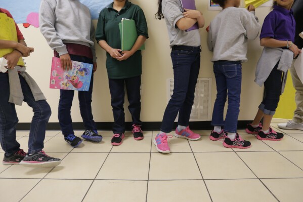 FILE - Migrant teens line up for a class at a "tender-age" facility for babies, children and teens, in Texas' Rio Grande Valley, in San Benito, Texas, Aug. 29, 2019. The Biden administration struggled to properly vet and monitor the homes where they placed a surge of migrant children who arrived at the U.S.-Mexico border in 2021. That's according to a federal watchdog report released Thursday. (APPhoto/Eric Gay File)